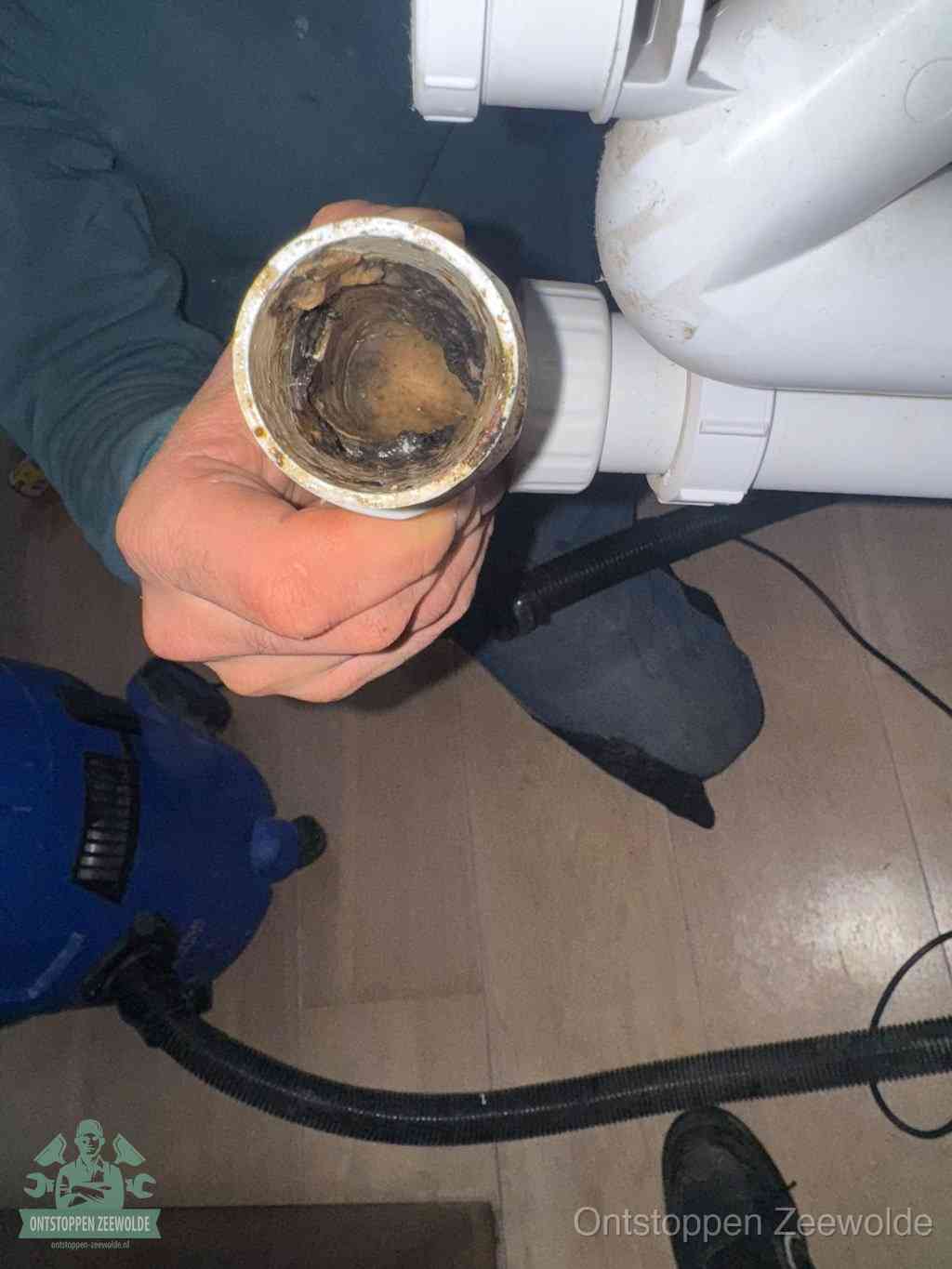 Een losgekoppeld PVC-afvoerbuisstuk dat van binnen volledig is dichtgeslibd met vet en vuil, de meest voorkomende oorzaak van verstoppingen in Zeewolde