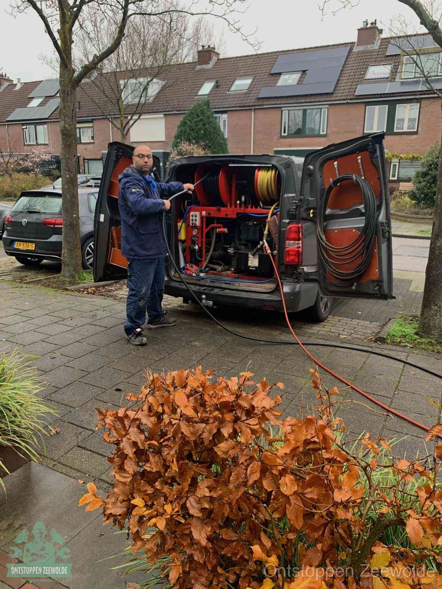 Een monteur staat bij zijn open bestelbus met hogedruk-rioolreinigingsapparatuur, klaar om binnen 30 minuten uit te rukken voor een spoedverstopping in Zeewolde