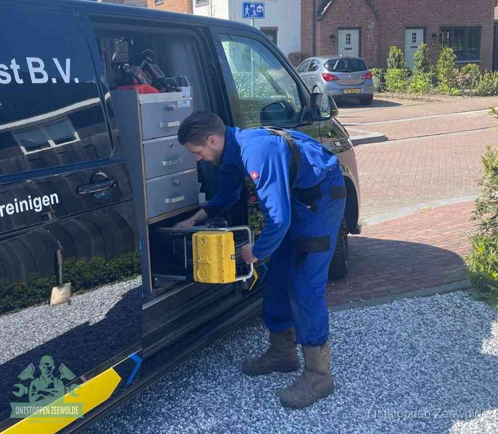 Een monteur pakt gereedschap uit de bedrijfsbus, het moment om een professionele ontstoppingsdienst in te schakelen in Zeewolde